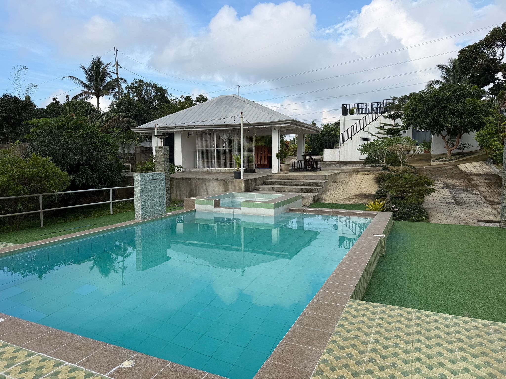 The pool from its corner, with turf lawn, the kiddie pool and the pavilion beyond